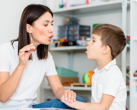 A speech-language pathologist modelling a sound for a child